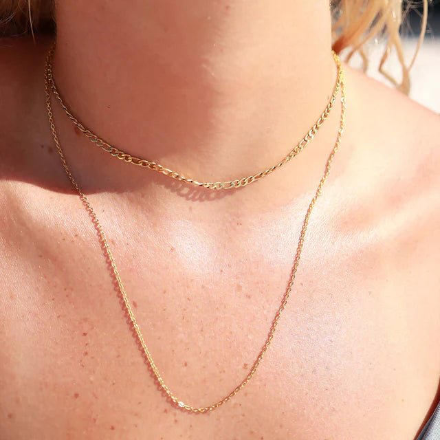 Cable chain necklace in gold, two-layer set with a short choker and a longer chain on model’s neck