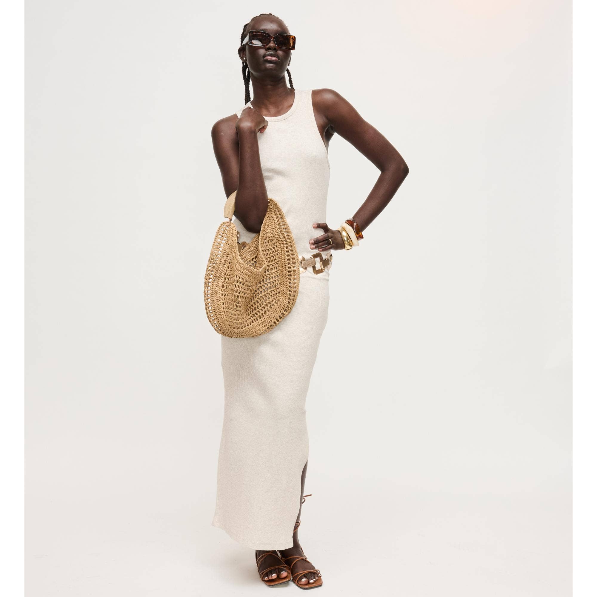 Camden Hobo bag, natural woven straw by Urban Expressions, carried with cream dress and sandals.
