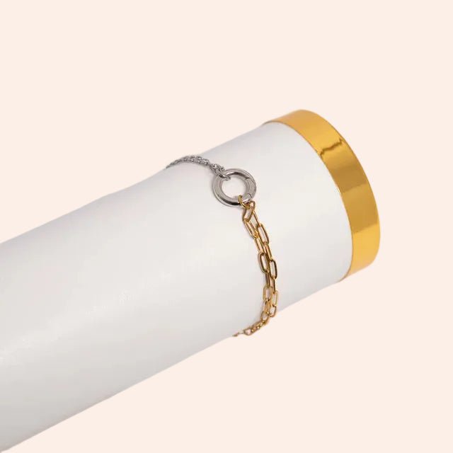 Two-piece bracelet set: charm holder mixed-metal bracelet (gold chain, silver ring) and a gold cuff on a white display