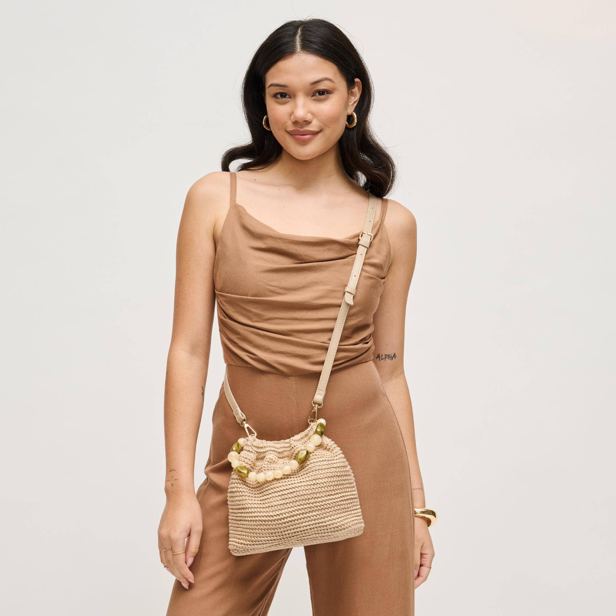 Urban Expressions Emery Crossbody bag in natural beige with woven knit texture and beaded accents.