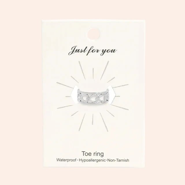 Heart toe ring, silver metal with heart cutouts, displayed on a card.