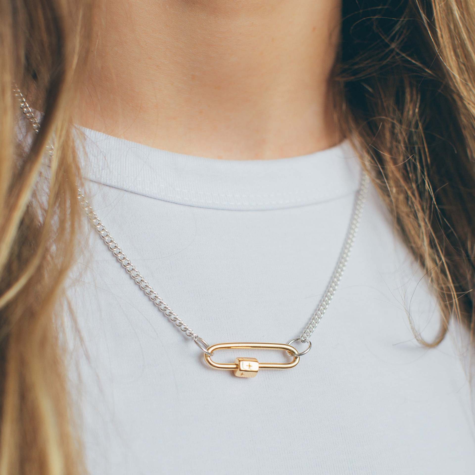 Story Lock Necklace with silver chain and gold-tone lock pendant.