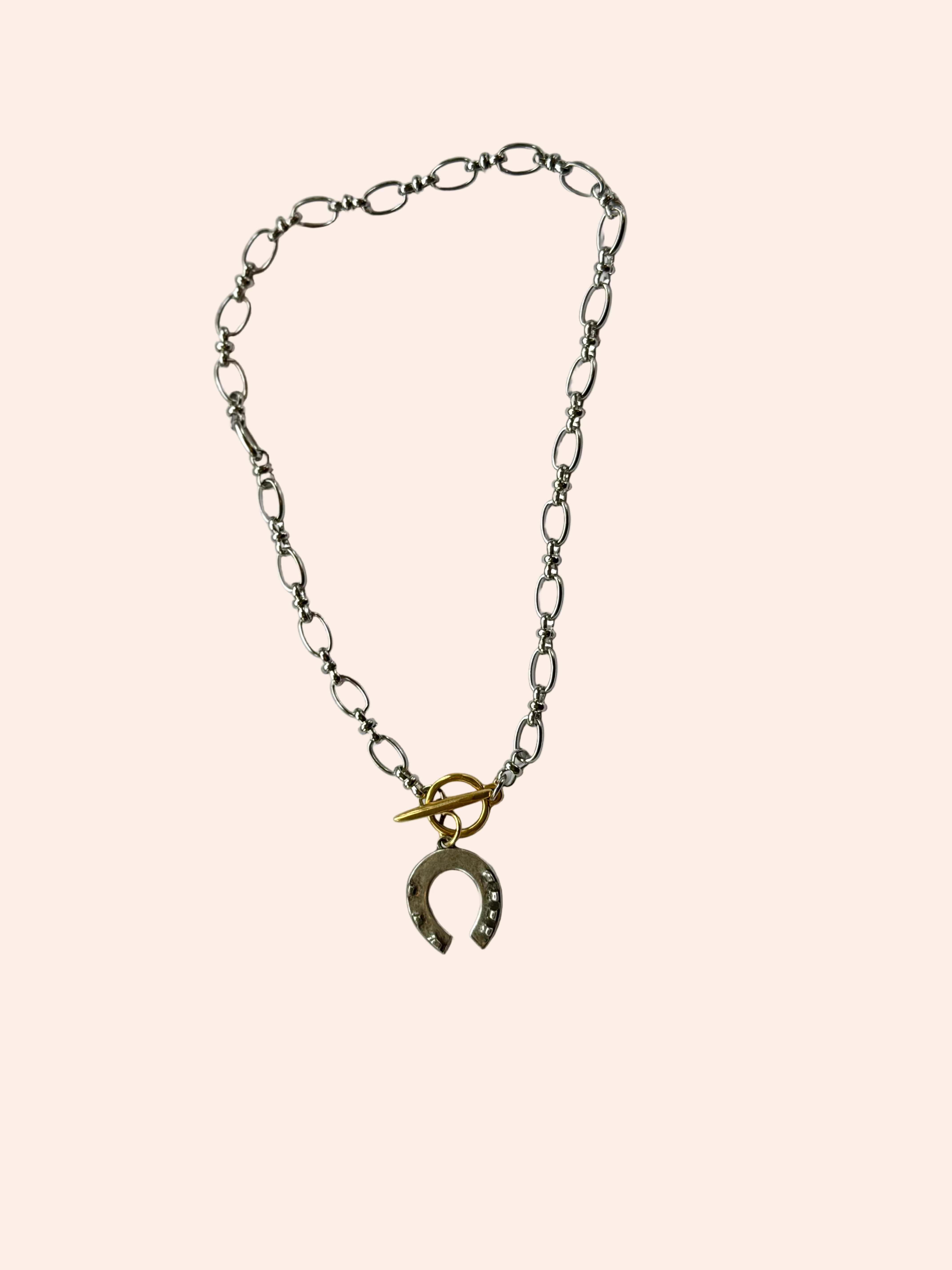Necklace with a horseshoe charm on a white background