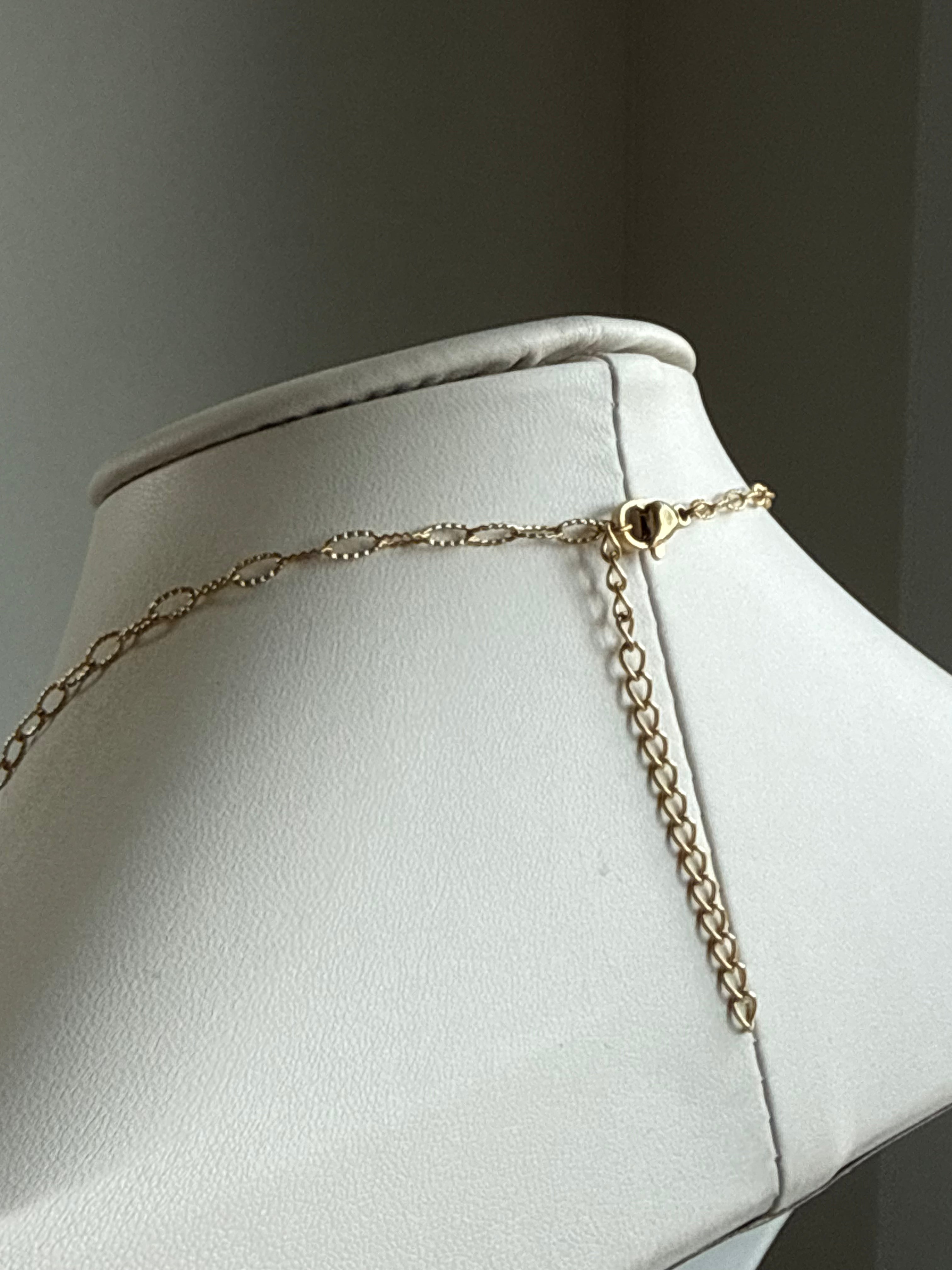 Signature Chain / Everyday Paperclip necklace, gold-tone chain on a white display bust