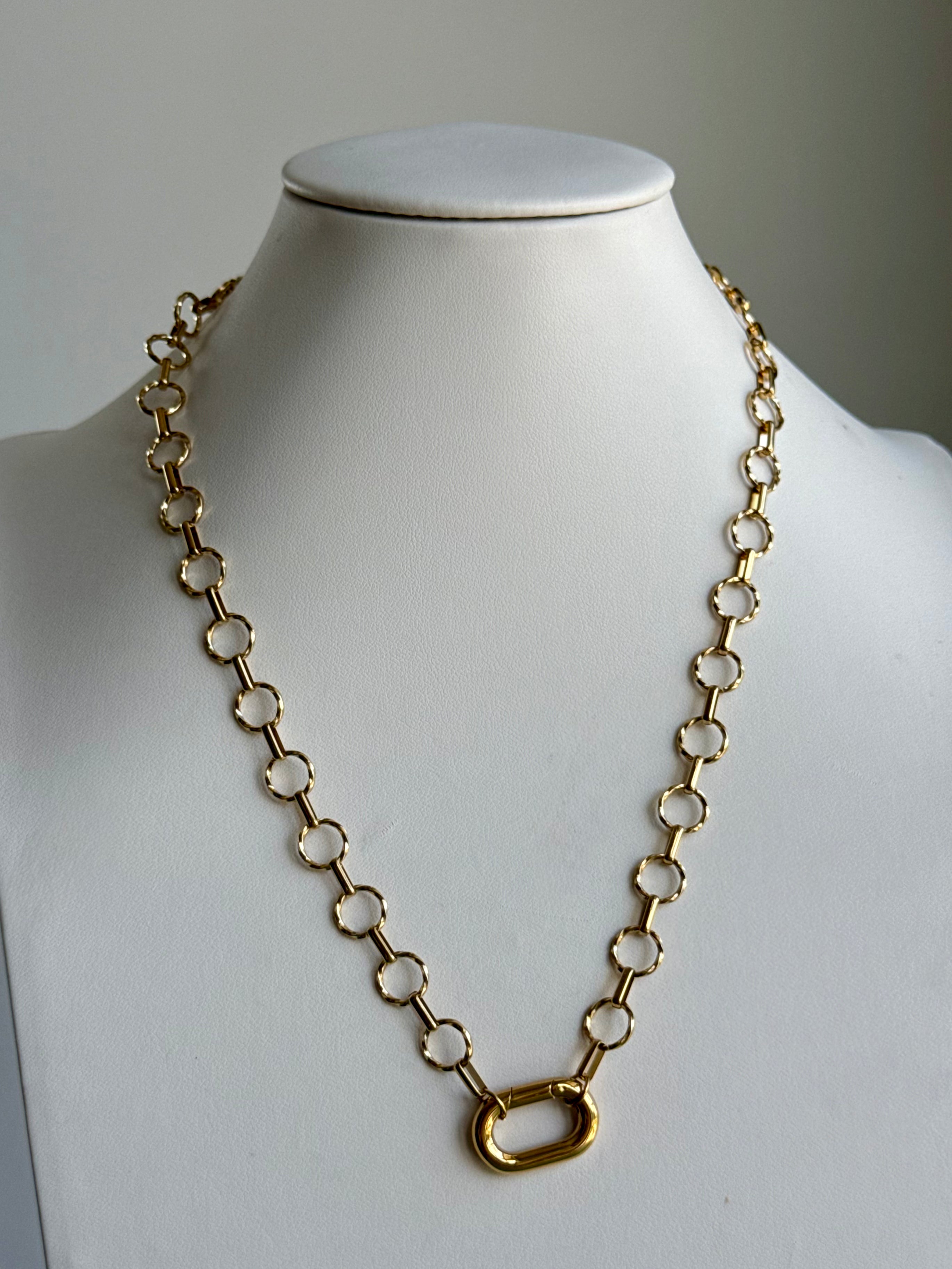 Signature Chain / Classic Loop necklace in gold-tone metal with circular links on a white display bust.