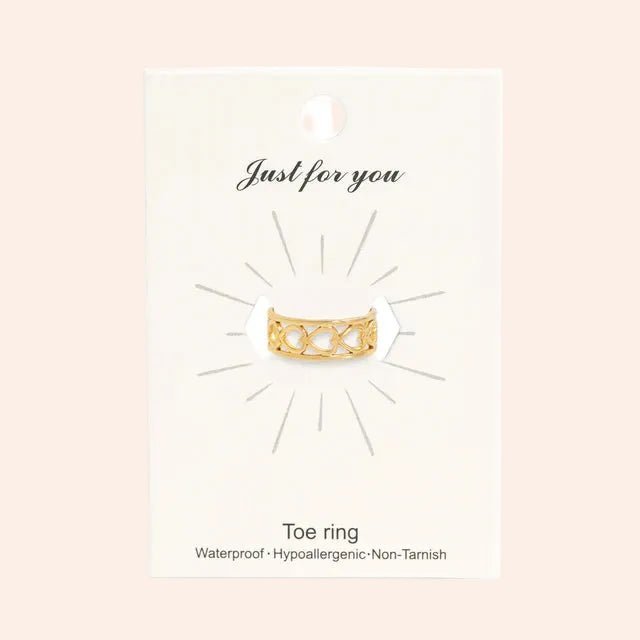 Heart toe ring with gold-tone band and heart-cutout design on white packaging card