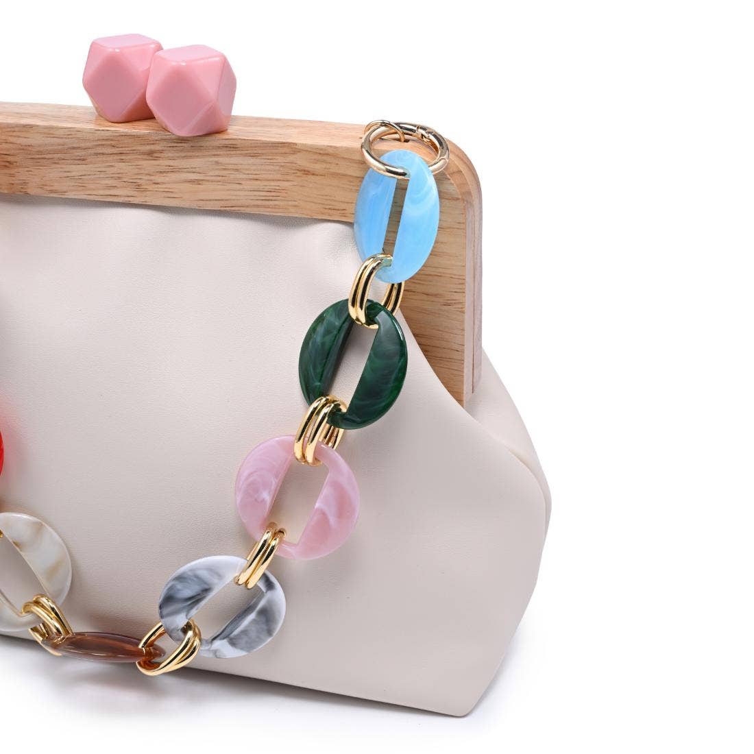 Talullah Ivory Cameo Evening Bag by Urban Expressions with colorful linked chain strap; pink cube earrings nearby.